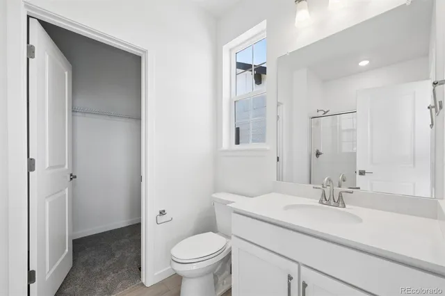 a bathroom with a granite countertop sink a toilet and a mirror