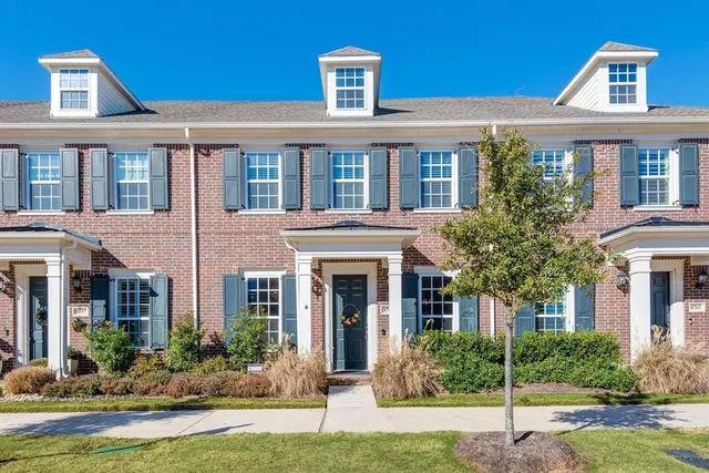 front view of a brick house with a yard