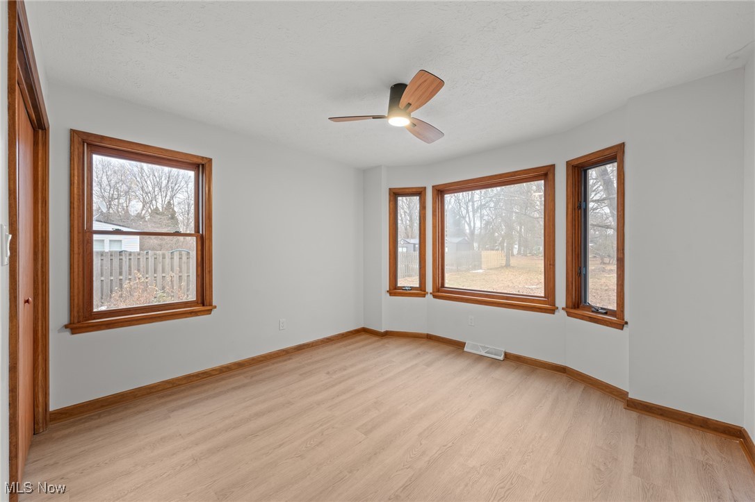 5266 Wilson Mills Road Cleveland, OH 44143 - Photo 22 of 50 Empty room with light wood-type flooring, ceiling fan, plenty of natural light, and a textured ceiling