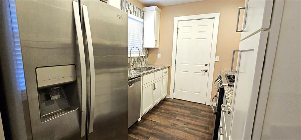 1291 Lorenzo Drive Southwest Atlanta, GA 30310 - Photo 7 of 17 a kitchen with stainless steel appliances a refrigerator a stove and white cabinets