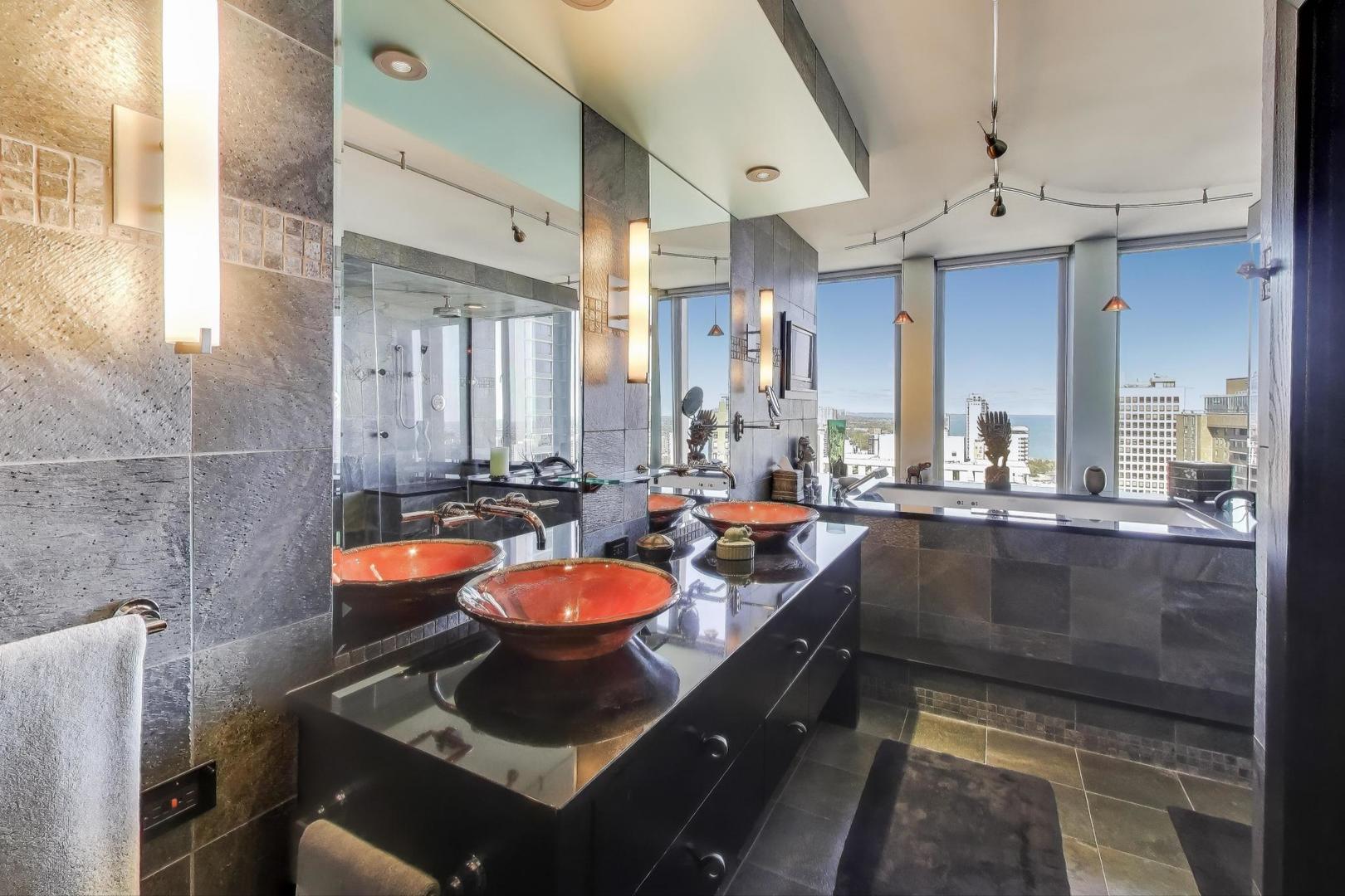 100 East Walton Street, Unit 42F Chicago, IL 60611 - Photo 33 of 52 a bathroom with a sink a large mirror and a bathtub