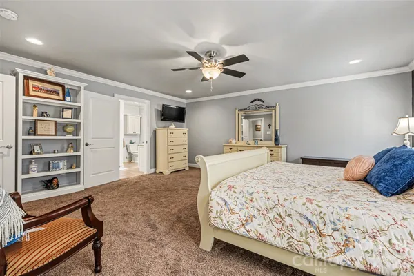 a bedroom with a large bed and a chandelier