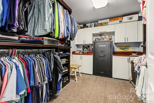a view of walk in closet with clothes and shoes