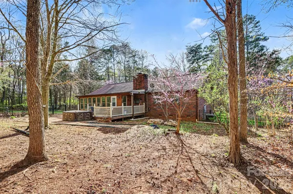 a view of a house with a yard tree and wooden fence