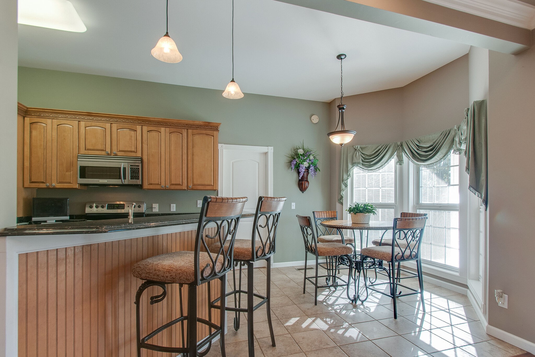 1230 Grindstone Hollow Road Dickson, TN 37055 - Photo 13 of 50 a kitchen with stainless steel appliances granite countertop a stove top oven a sink a dining table and chairs with wooden floor