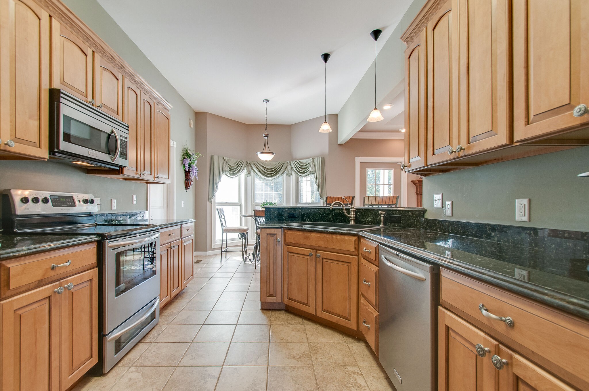1230 Grindstone Hollow Road Dickson, TN 37055 - Photo 17 of 50 a kitchen with stainless steel appliances granite countertop a sink and dishwasher a stove top oven with wooden floor