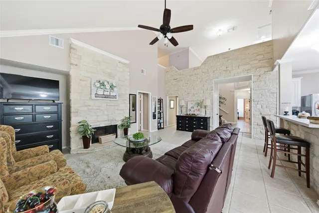 a living room with furniture a fireplace and a chandelier