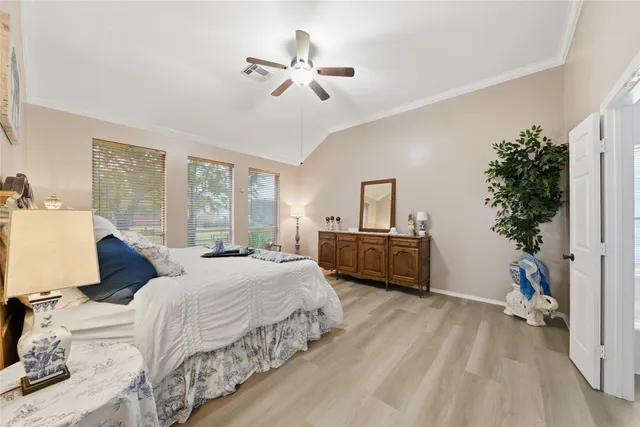 a bedroom with a bed a large window and potted plant