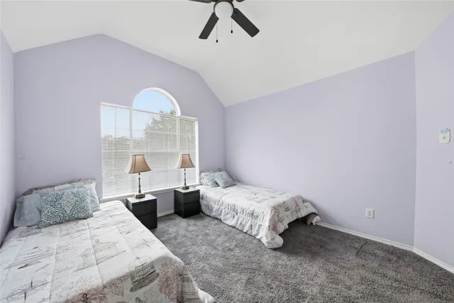 a bedroom with two beds and a large window