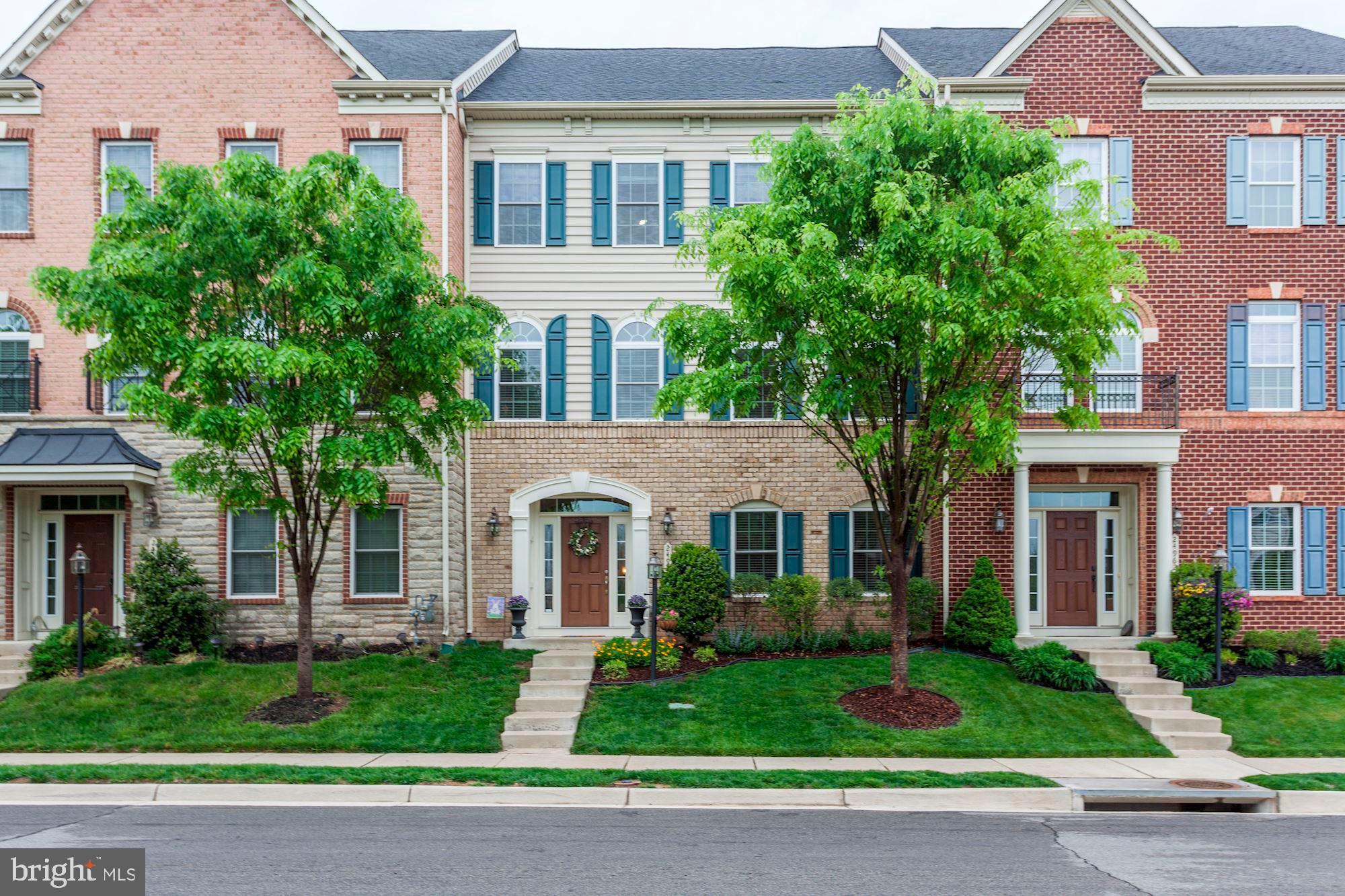 a front view of a house with a yard and potted plants