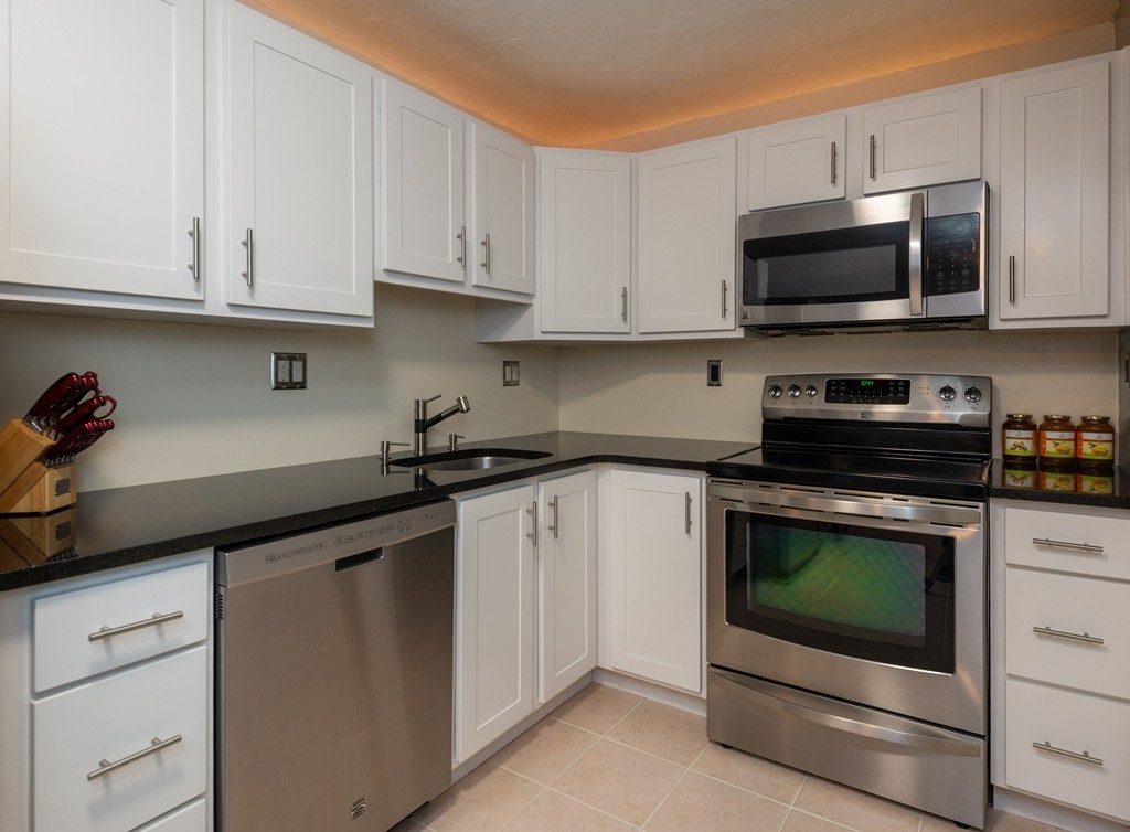 189 Littleton Road, Unit 19 Chelmsford, MA 01824 - Photo 14 of 42 a kitchen with white cabinets and stainless steel appliances