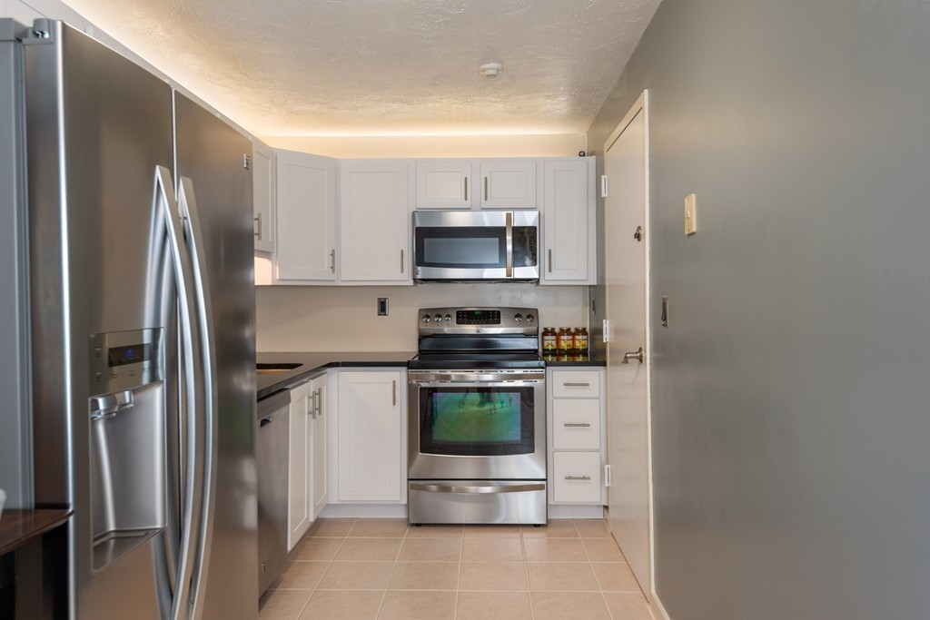 189 Littleton Road, Unit 19 Chelmsford, MA 01824 - Photo 15 of 42 a kitchen with stainless steel appliances granite countertop a refrigerator and a stove