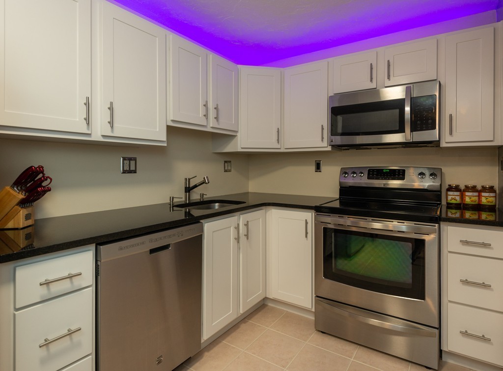 189 Littleton Road, Unit 19 Chelmsford, MA 01824 - Photo 28 of 42 a kitchen with stainless steel appliances granite countertop a sink and a microwave