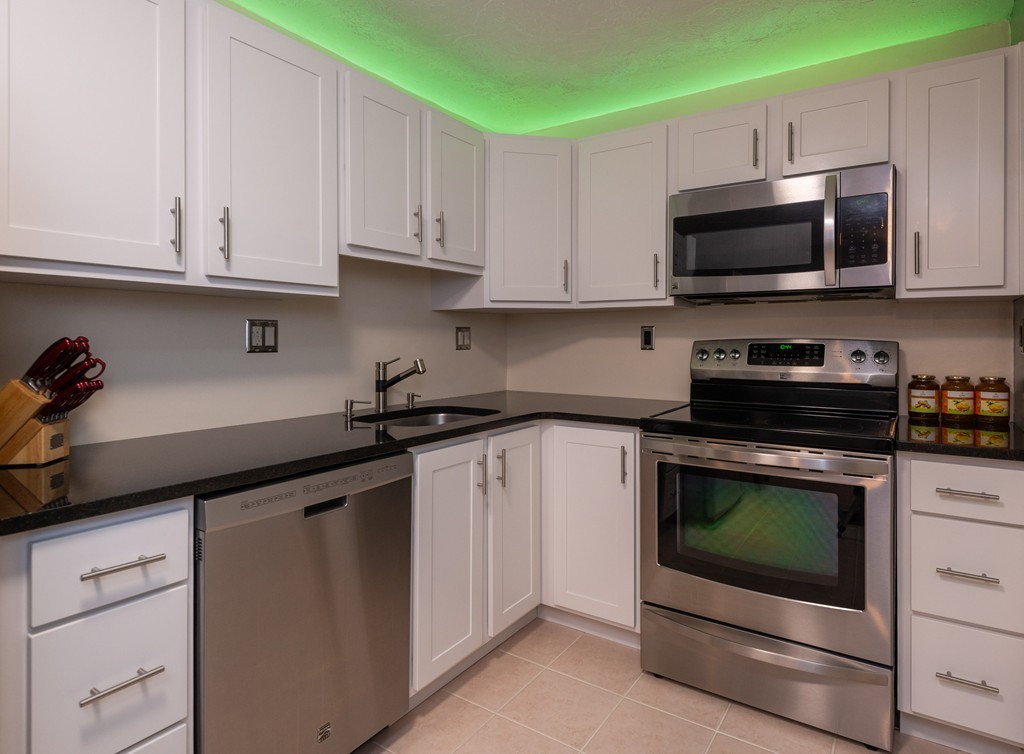 189 Littleton Road, Unit 19 Chelmsford, MA 01824 - Photo 29 of 42 a kitchen with white cabinets and stainless steel appliances