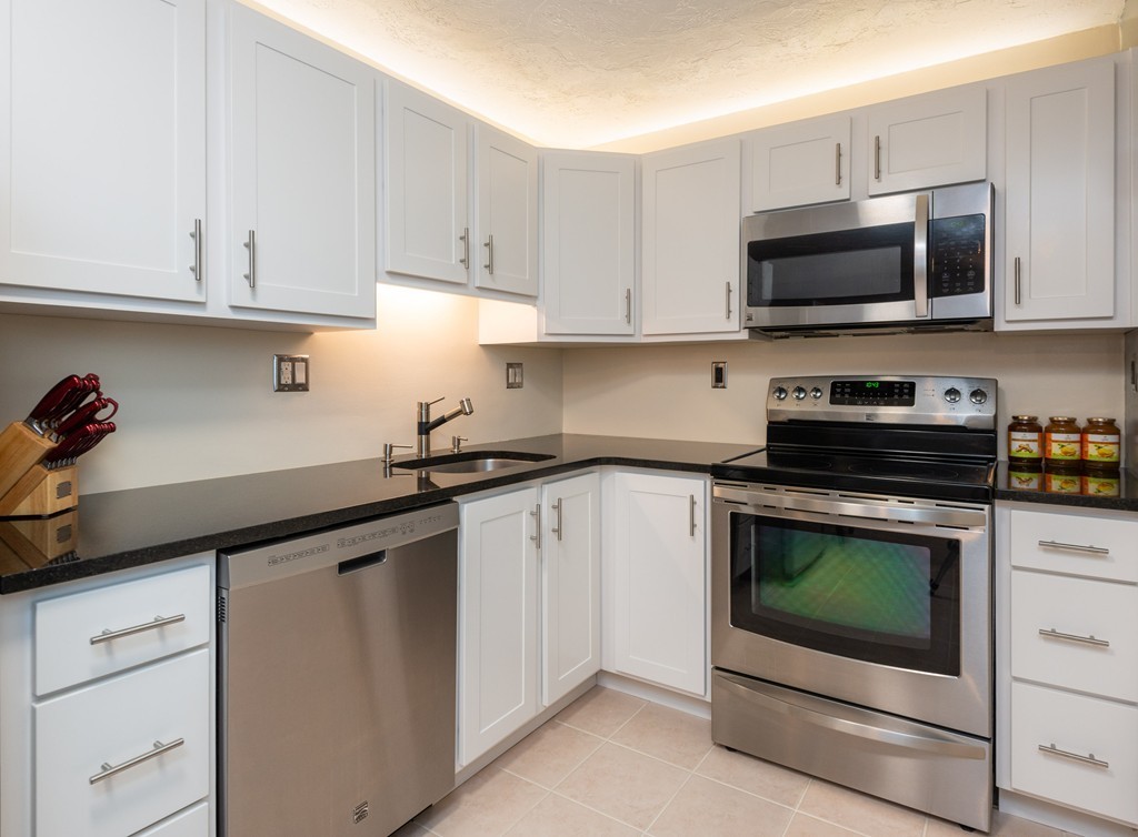 189 Littleton Road, Unit 19 Chelmsford, MA 01824 - Photo 3 of 42 a kitchen with white cabinets and stainless steel appliances