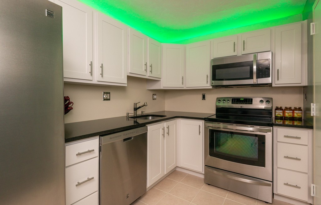 189 Littleton Road, Unit 19 Chelmsford, MA 01824 - Photo 8 of 42 a kitchen with stainless steel appliances granite countertop a stove a microwave and a refrigerator