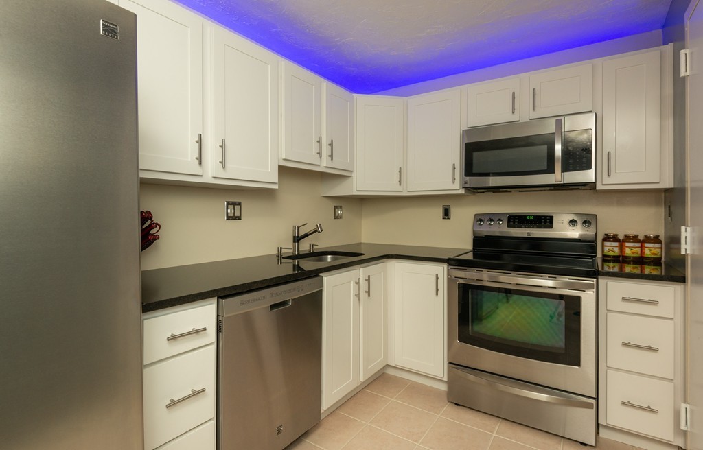 189 Littleton Road, Unit 19 Chelmsford, MA 01824 - Photo 9 of 42 a kitchen with stainless steel appliances granite countertop a stove microwave and sink