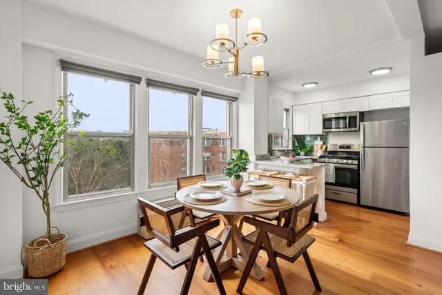 a dining room with furniture a chandelier and wooden floor