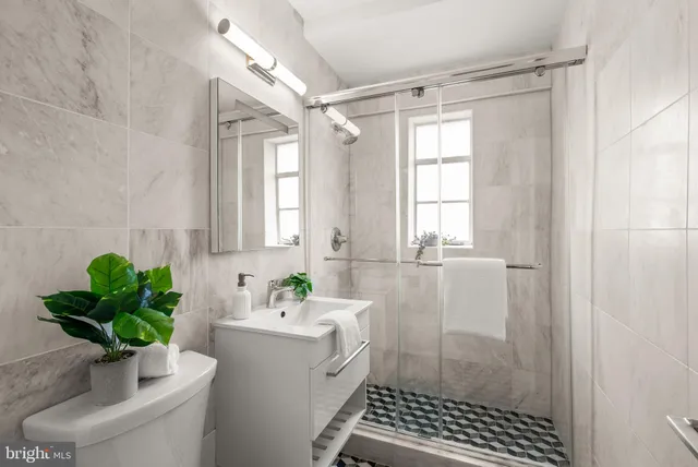 a bathroom with a sink a window and a shower