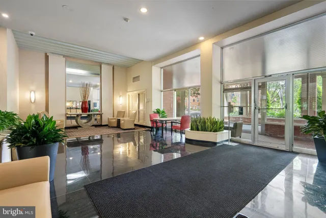 a living room with furniture large windows and wooden floor