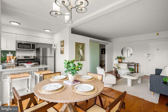 a dining room with wooden floor a chandelier a wooden table and chairs