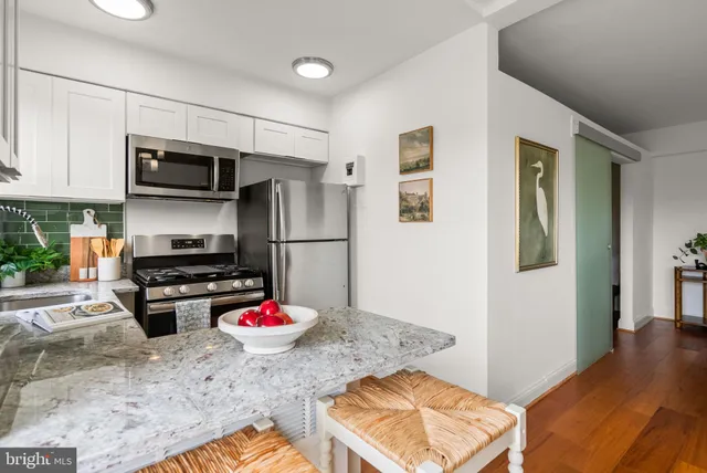 a kitchen with stainless steel appliances granite countertop a stove refrigerator and microwave