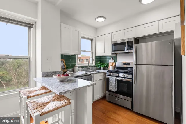 a kitchen with stainless steel appliances a refrigerator sink and microwave