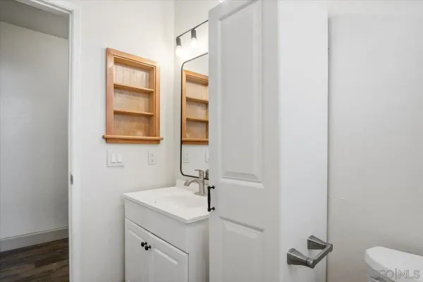 a bathroom with a granite countertop sink toilet and mirror