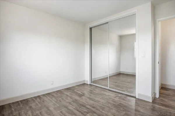 an empty room with wooden floor and door