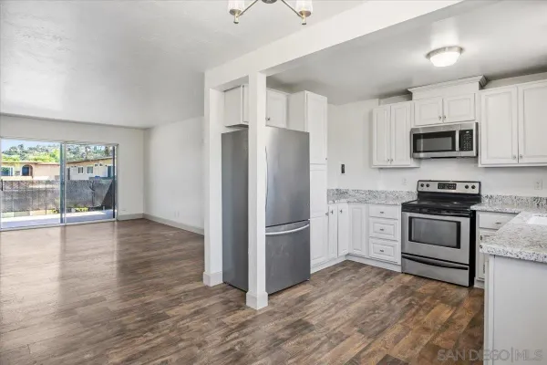 a kitchen with granite countertop a refrigerator stove and sink