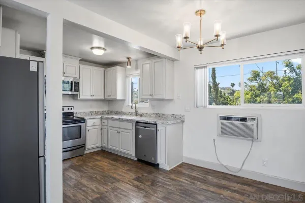 a kitchen with kitchen island granite countertop a stove cabinets and refrigerator
