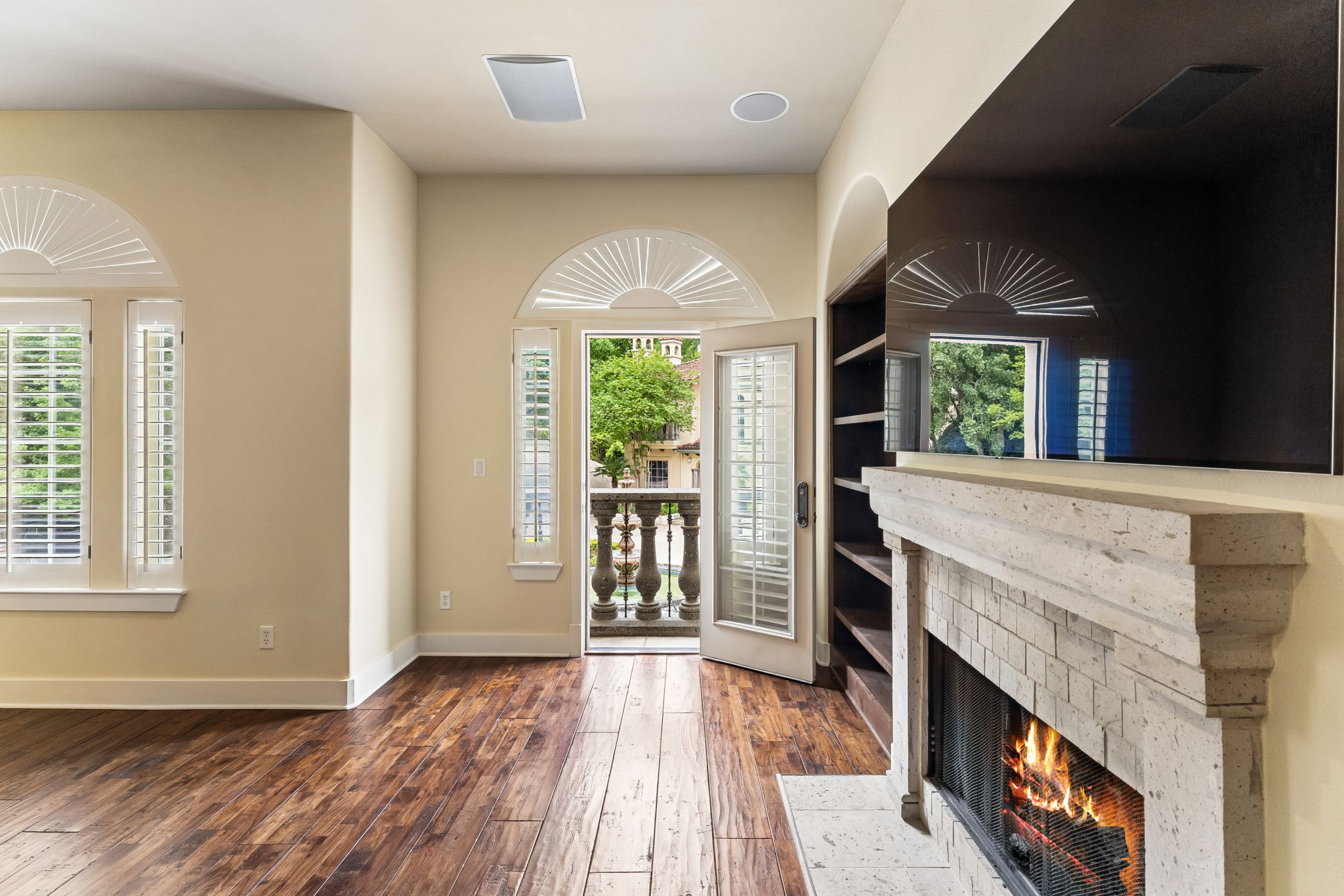 1529 Barton Springs Road, Unit 9 Austin, TX 78704 - Photo 21 of 37 This living space features hardwood floors, arched windows with plantation shutters, and a balcony with decorative balusters