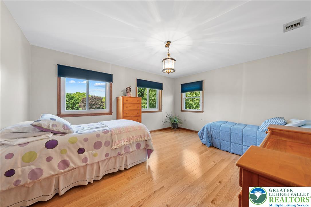 947 Tamenend Road Bath, PA 18014 - Photo 22 of 61 Hardwood floors and generous windows elevate this spacious bedroom.