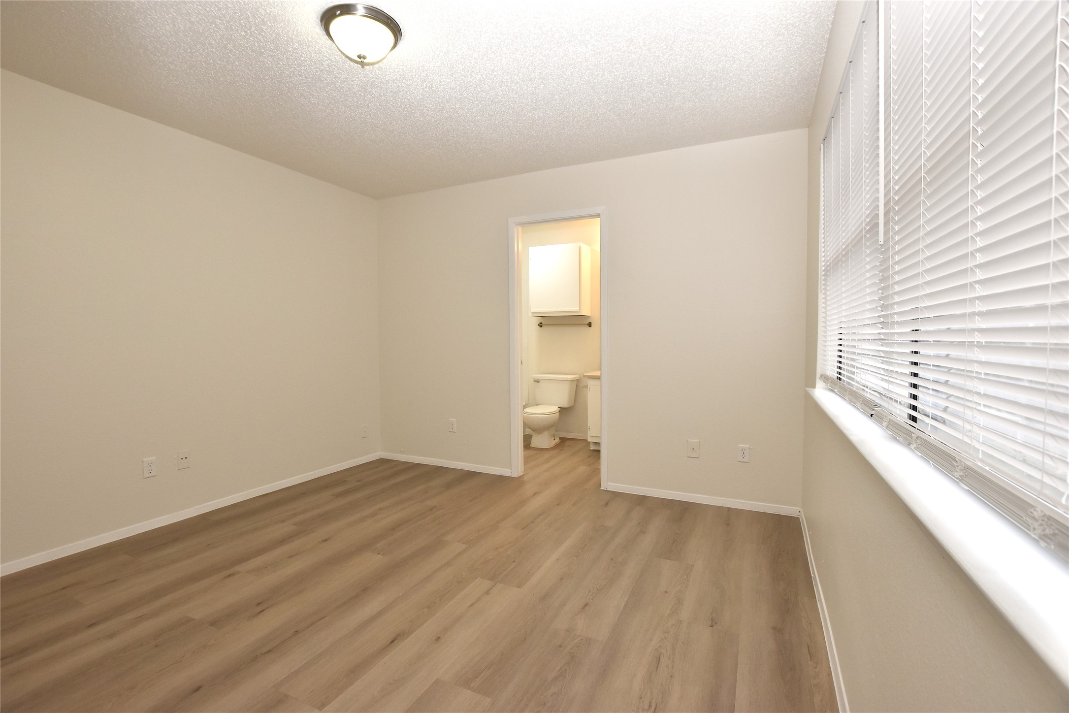 2801 West Slaughter Lane, Unit A Austin, TX 78748 - Photo 11 of 15 a view of an empty room with wooden floor and a window
