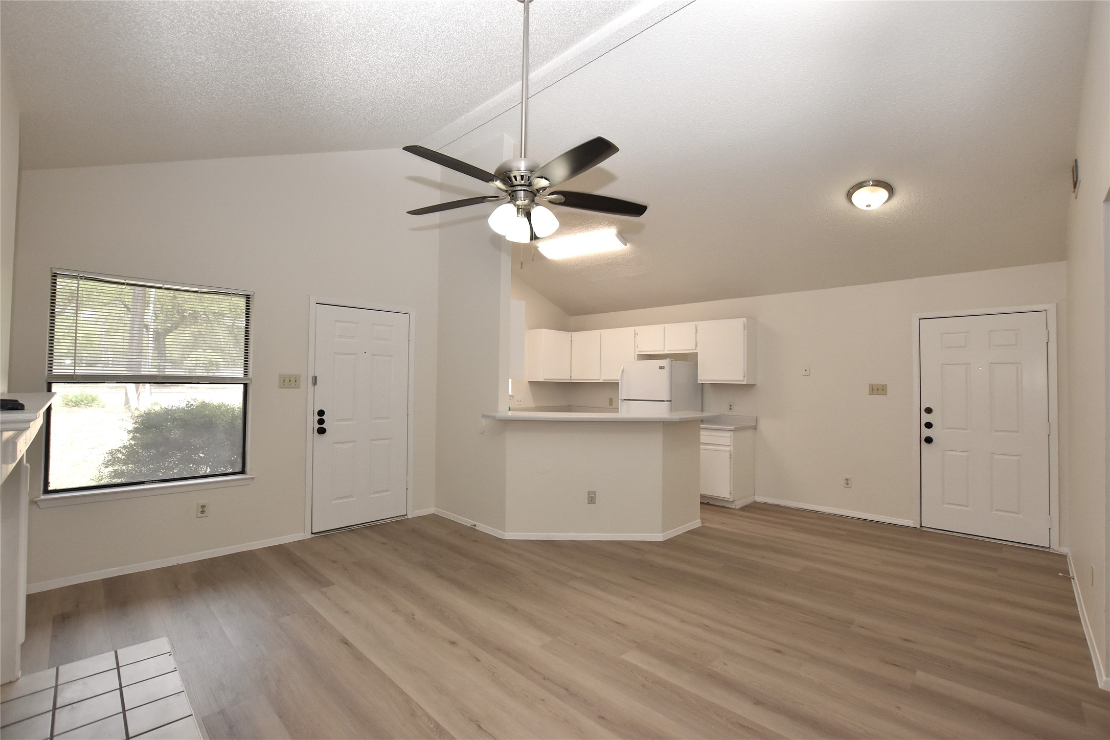 2801 West Slaughter Lane, Unit A Austin, TX 78748 - Photo 3 of 15 a view of a kitchen with wooden floor and a ceiling fan