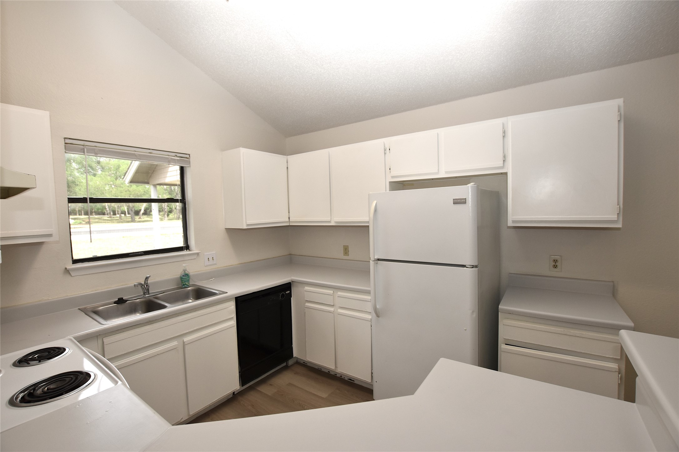 2801 West Slaughter Lane, Unit A Austin, TX 78748 - Photo 8 of 15 a kitchen with a sink a stove a refrigerator and white cabinets