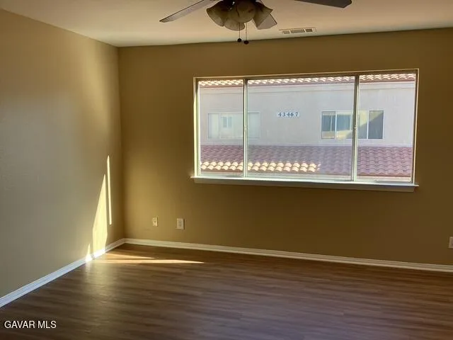 an empty room with wooden floor and a window