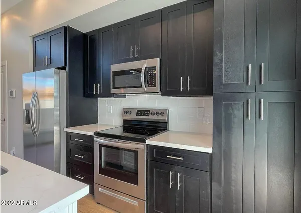a kitchen with granite countertop wooden cabinets and stainless steel appliances