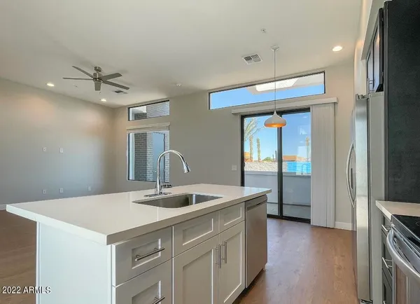 a kitchen with a sink a counter top space and stainless steel appliances