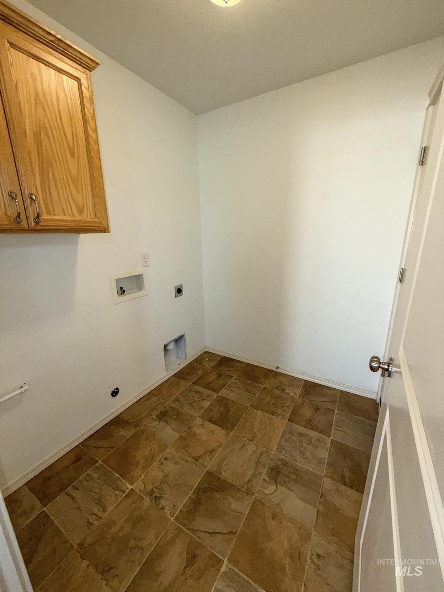 702 Emerald Street Rupert, ID 83350 - Photo 11 of 12 Laundry room featuring stone finish flooring, cabinet space, hookup for an electric dryer, and hookup for a washing machine