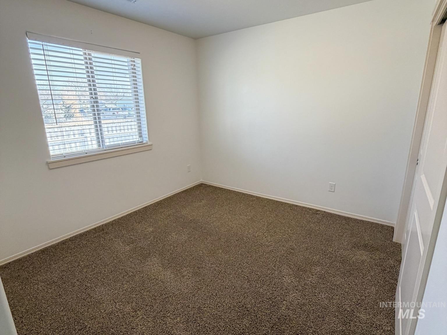 702 Emerald Street Rupert, ID 83350 - Photo 8 of 12 Unfurnished room featuring carpet floors and baseboards
