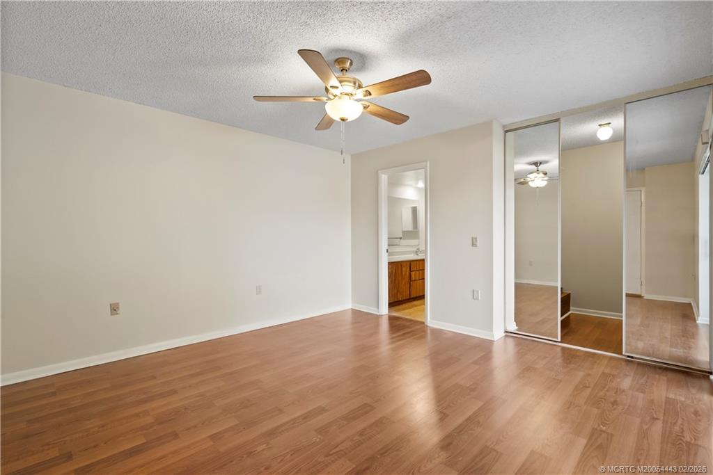 2930 Southwest Sunset Trace Circle Palm City, FL 34990 - Photo 13 of 31 an empty room with wooden floor and a ceiling fan