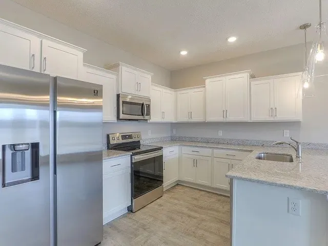 a kitchen with a sink stainless steel appliances and cabinets