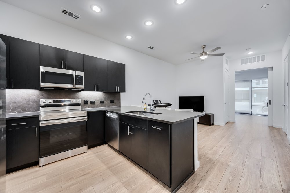 4801 Springdale Road, Unit 2107 Austin, TX 78723 - Photo 5 of 26 a kitchen with a sink stainless steel appliances and cabinets