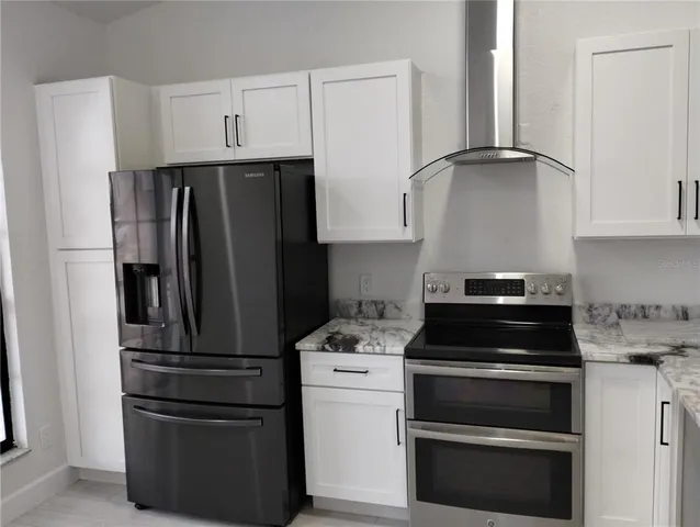 a kitchen with refrigerator and cabinets