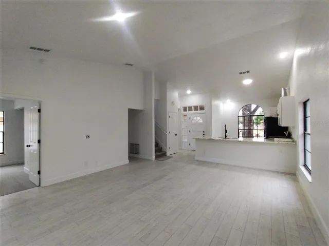 a view of a big room with wooden floor and windows