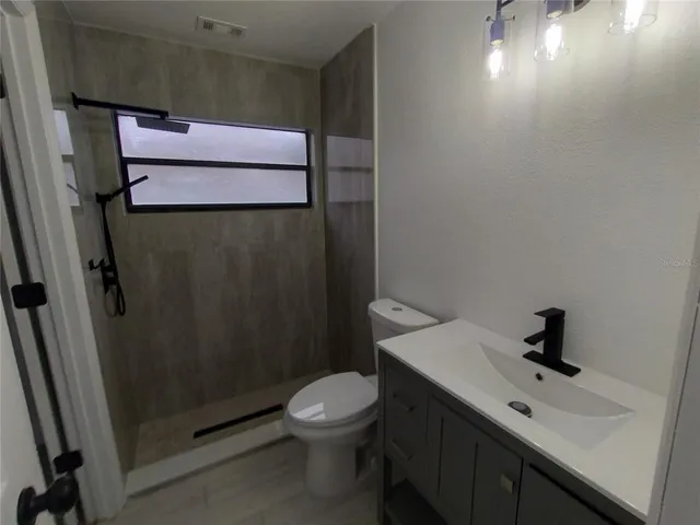 a bathroom with a sink and mirror with toilet