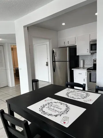 a kitchen with a refrigerator and a stove top oven