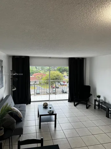 a living room with furniture and a floor to ceiling window