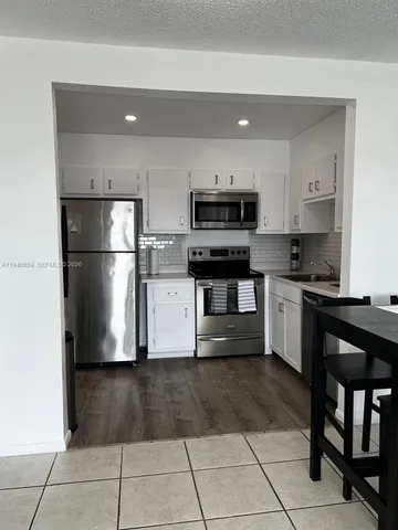 a kitchen with a refrigerator a microwave and cabinets